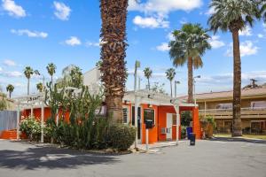 a palm tree in front of a building with palm trees at Sol Springs Inn in Palm Springs