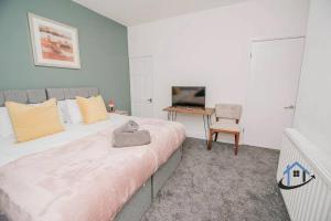 Schlafzimmer mit einem Bett, einem Schreibtisch und einem TV in der Unterkunft Balby Casa king beds parking workspace wifi corporates pets in Balby