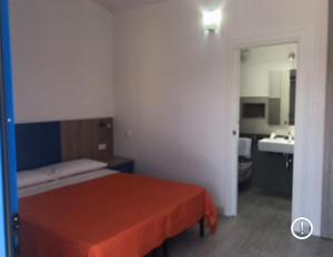 - une chambre avec un lit et une salle de bains pourvue d'un lavabo dans l'établissement Bed & Blu, à La Caletta