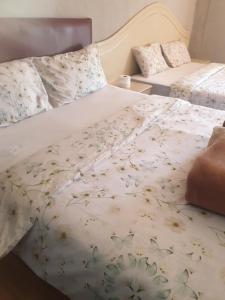 a bedroom with two beds with flowers on them at Randgate guesthouse in Randfontein