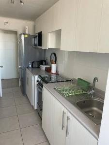 a kitchen with a sink and a stove top oven at Acogedor departamento centro Iquique in Iquique