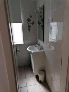 a white bathroom with a sink and a shower at Apartment & Rooms Lilis in Izola