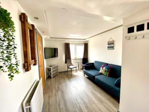 a living room with a blue couch and a tv at Kennedy House by Blackpool Service Apartments in Blackpool