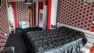 a bedroom with a black and white bed and red walls at Luxury Apartments Burgas in Burgas City