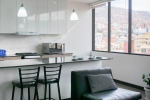 a kitchen with two chairs and a bar with a view at Sky Suites Sopocachi in La Paz