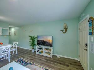 a living room with a tv on a wall at Trendy 1BD Balcony Pool Small fam or couples stay in Ocean City