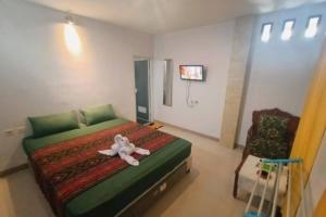 Un dormitorio con una cama con una flor. en OYO 92756 Kos Moncok en Tjakranegara