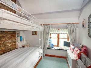 Railway Cottage في كاميلفورد: غرفة نوم مع سريرين بطابقين ومكتب