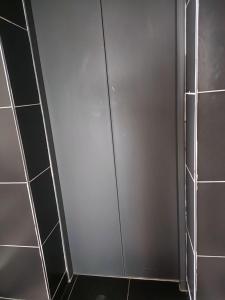 uma cabina de duche com uma porta de correr na casa de banho em Lakira Nita's place em Nairobi