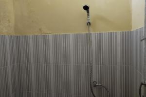 y baño con ducha con cabezal de ducha. en OYO 92756 Kos Moncok en Tjakranegara