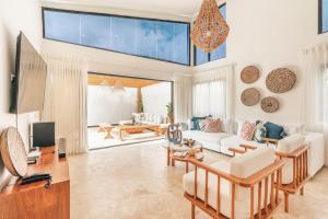 ein Wohnzimmer mit weißen Möbeln und einem großen Fenster in der Unterkunft Charming villa with private pool in Juan Dolio in Juan Dolio