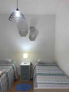 um quarto com 2 camas e uma mesa de cabeceira com um candeeiro em Casona centrica alameda Mendoza em Mendoza