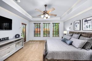 een slaapkamer met een bed en een plafondventilator bij Parkside Serenity Bear Creek and Sam Race Track in Houston