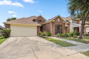 a brick house with a garage in a driveway at Parkside Serenity Bear Creek and Sam Race Track in Houston