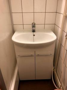 a bathroom with a white sink and white tiled walls at JK-Apartment Asemakatu in Lapua +7 photos