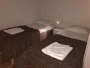 - 2 lits dans une chambre avec des serviettes blanches dans l'établissement JK-Apartment Asemakatu, à Lapua