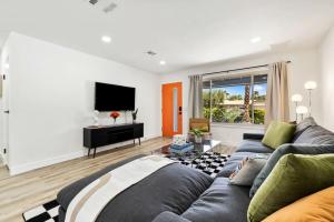 a living room with a couch and a television at Acacia Retreat by Rather Be Properties in Palm Springs