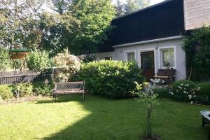 un patio con un banco y una casa en Urlaub in Engelswacht en Sundhagen-Niederhof