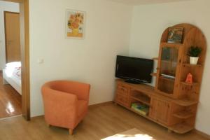 sala de estar con TV y silla en Urlaub in Engelswacht en Sundhagen-Niederhof