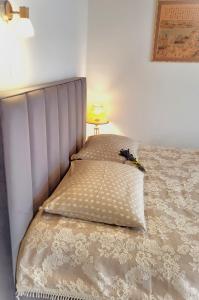 1 cama con cabecero y lámpara en una habitación en Nemirsetos kopos, en Palanga