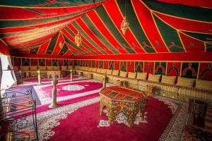 una camera con soffitto rosso e verde con tavolo di Las Palmeras Guest House a Marrakech