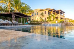 uma piscina de resort com cadeiras e um edifício em 3BD Golf Front Beach Club and Hot Tub in PLC em San José del Cabo