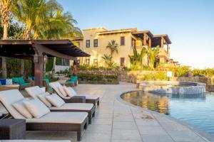 a patio with couches and a pool in front of a house at 3BD Golf Front Beach Club and Hot Tub in PLC in San José del Cabo