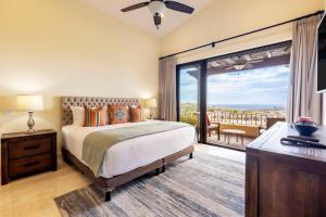 um quarto com uma cama e uma varanda com vista em 3BD Golf Front Beach Club and Hot Tub in PLC em San José del Cabo