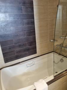 a bathroom with a tub and a glass shower at Appartamento Elisir Domina Coral Bay in Sharm El Sheikh
