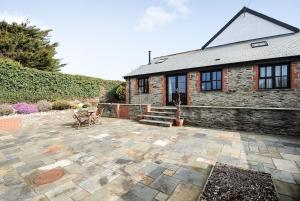 a brick house with a patio and a building at Long Linhay in Woolacombe