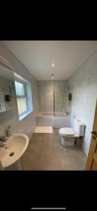 y baño con lavabo, aseo y bañera. en Kilbarth Cottage en Haverfordwest