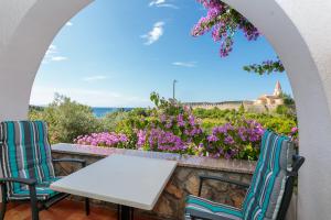 a table and two chairs on a balcony with flowers at Apartments Delfin in Krk