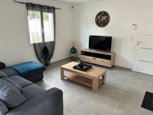a living room with a couch and a tv at Vacances en Ardèche "maison pont d'arc" in Vallon-Pont-dʼArc