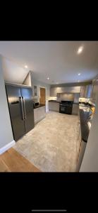 a large kitchen with stainless steel appliances and a tile floor at Kilbarth Cottage in Haverfordwest