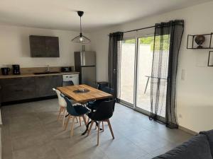 una cucina e una sala da pranzo con tavolo e sedie di Vacances en Ardèche "maison pont d'arc" a Vallon-Pont-dʼArc Altre 4 foto