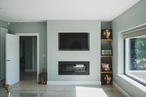 uma sala de estar com lareira e uma televisão de ecrã plano em Erinona House em Stonefort