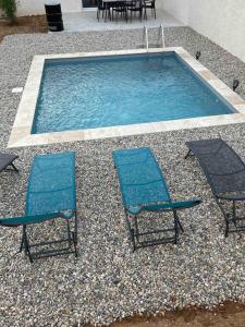 duas cadeiras e uma piscina com duas cadeiras em Vacances en Ardèche "maison pont d'arc" em Vallon-Pont-dʼArc