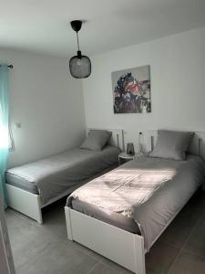 1 dormitorio con 2 camas y lámpara en Vacances en Ardèche "maison pont d'arc" en Vallon-Pont-dʼArc