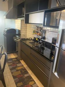 a kitchen with a sink and a refrigerator at Apto Andalus-Frente Hospital Einstein-Estádio MorumBis in Sao Paulo