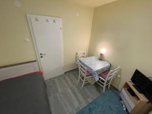 mały pokój ze stołem, krzesłami i drzwiami w obiekcie Apartman Stela w Nin