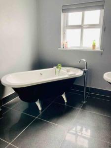 a bath tub in a bathroom with a window at Peaceful Portstewart pad in Portstewart