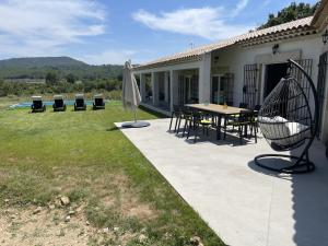 une terrasse avec une table, des chaises et un parasol dans l'établissement Villa en Provence, à Rians