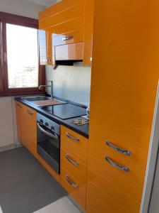 a kitchen with orange cabinets and a stove at Exotic Home San Paolo Roma in Rome