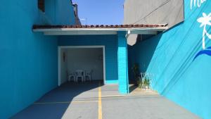 un edificio blu con una parete blu e un patio di Mar dos Sonhos Suítes a Ubatuba