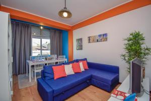 a living room with a blue couch and a table at Cozy and Family apartment in Lisbon