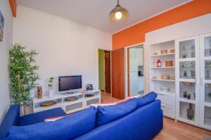 a living room with a blue couch and an orange wall at Cozy and Family apartment in Lisbon