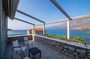 a balcony with chairs and a view of the water at Laconian Collection Kotronas Residence in Kotronas