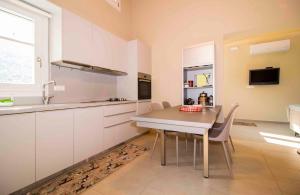 a kitchen with a table with chairs and a sink at Laconian Collection Kotronas Residence in Kotronas