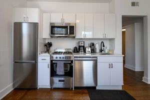 eine Küche mit Küchengeräten aus Edelstahl und weißen Schränken in der Unterkunft Work-Stay Near Yale & Hospitals in New Haven
