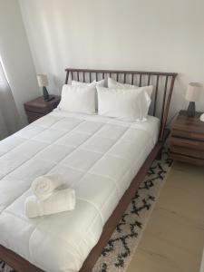 a bed with white sheets and towels on it at Walk to Downtown UT Sports Famous Dining and abundant Nightlife from this Luxury Condo w 3 restaurants in the complex in Austin